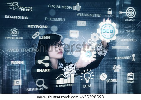 Young businesswoman working with a virtual screen while using SEO button. Concept of Search Engine Optimization
