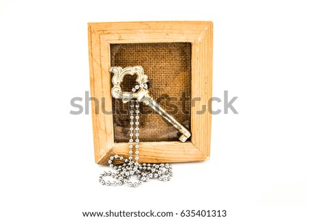 Old key in picture frame on white background