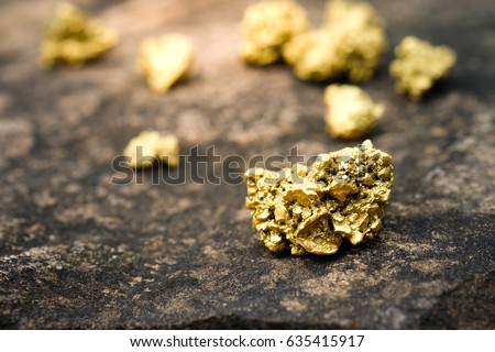 A lump of gold on a stone floor Royalty-Free Stock Photo #635415917