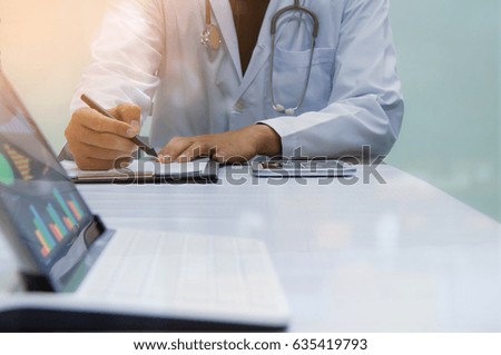 Smart medicine doctor working with modern computer and digital tablet at desk in the hospital