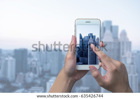 Man hand taking photo of the city with a smartphone
