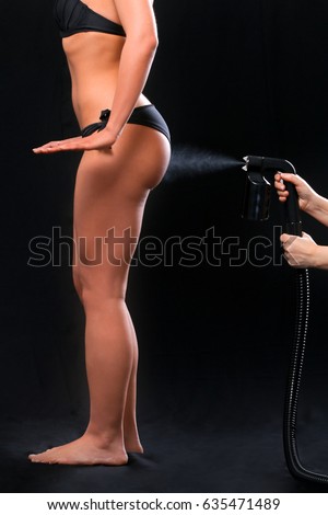 Woman body paint with airbrush in professional beauty salon Royalty-Free Stock Photo #635471489