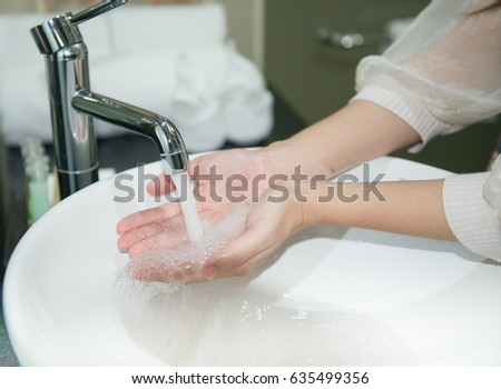 Washing Hands with streaming water under tap in bathroom. Hygiene,Hand washing. woman washing hands under a tap water