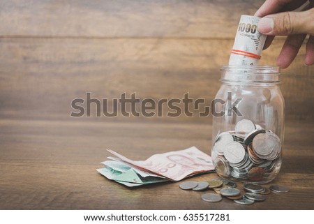 Money in the glass on wooden background