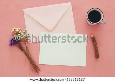 vintage mockup with flowers, cup of coffee and blank letter pink on wooden background