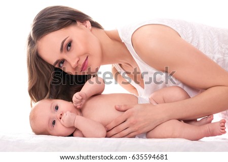 Young beautiful blonde girl near child. Beauty Woman smiling. The baby lies on the surface. isolated on white background. mother's love and care