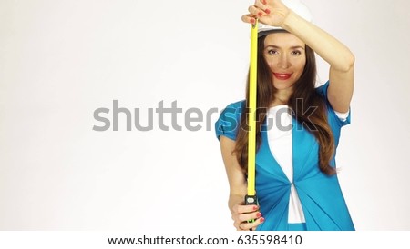 Beautiful female construction engineer or architect in hard hat using measure tape against white background