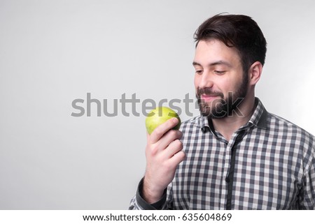 Men eats an apple. bearded guy holding an apple. vegetarian preparing dinner.