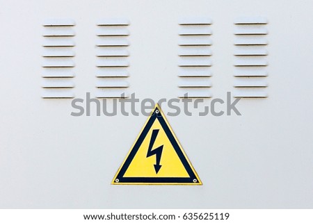 High voltage sign on the background of the gray doors of the switchboard