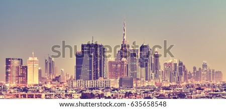 Color toned panoramic picture of Dubai skyline at sunset, United Arab Emirates.