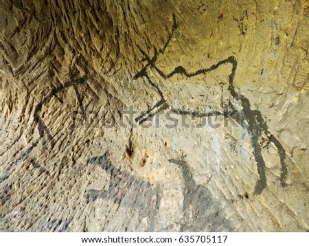 Black carbon paint of deer on sandstone wall, prehistorical picture. Abstract art in sandstone cave. Black carbon symbols on sandstone wall. Paint of human hunting,  prehistoric picture. Discovery 