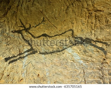 Black carbon paint of deer on sandstone wall, prehistorical picture. Art in  sandstone cave. Black carbon symbols on sandstone wall. Paint of human,,  prehistoric picture. Discovery of human history
