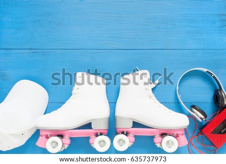 Sport, healthy lifestyle, roller skating background. White roller skates, headphones and white baseball cap. Flat lay, top view.