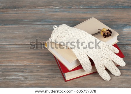 Open book, hardback books on wooden table, rose and white gloves knitted crochet Back to school. Copy space for text