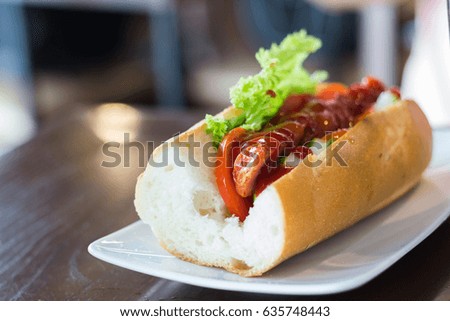 Hot dog with pickles, tomato and lettuce