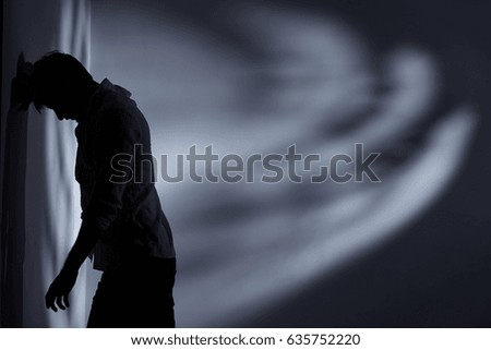 Depressed and broken man standing alone close to the wall Royalty-Free Stock Photo #635752220