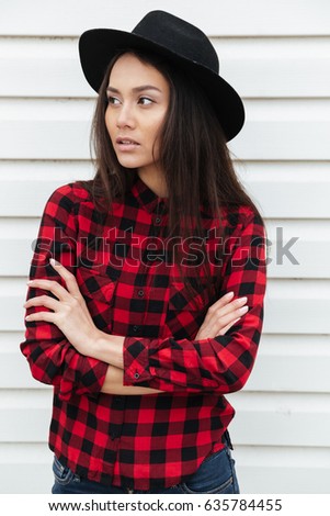 Picture of concentrated young caucasian lady walking outdoors. Looking aside.