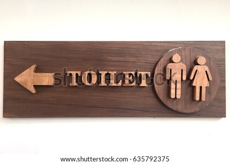 Toilet sign with man and woman on wooden background