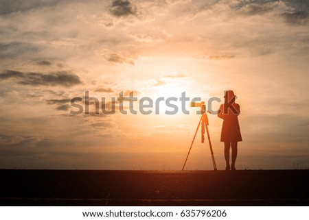 Sihouette girl photographer with sunset.