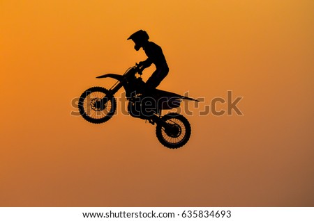 Practice day,silhouette of a motorcycle motocross jumping on sunset background.