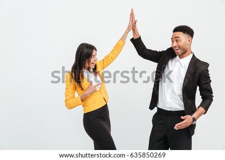 Picture of happy colleagues business team standing over white background isolated. Looking aside gives a high-five to each other.