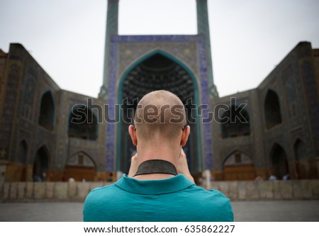 Tourist taking a picture of the Beuautiful ceiling dome wall of Entrance to the central Isfahan Mosque (Naghsh-e Jahan Mosque) in Iran