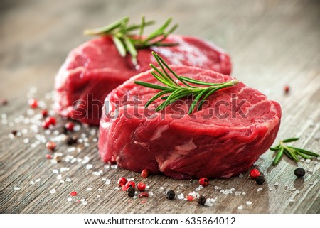 Raw beef fillet steaks with spices on wooden background Royalty-Free Stock Photo #635864012