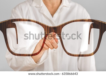 Person pointing with finger at glasses
