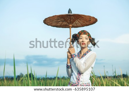 Traditional Burma fashion girl suit at outdoor rice paddy field, Myanmar culture lifestyle concept.