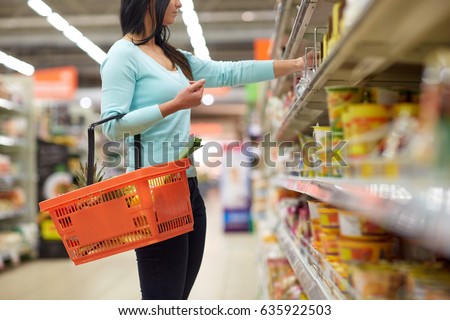 sale, shopping, consumerism and people concept - woman with food basket at grocery store or supermarket Royalty-Free Stock Photo #635922503