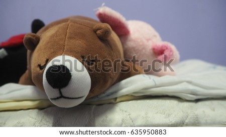 teddy bear doll sleeping on the bed