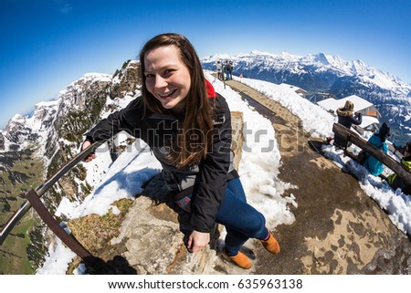 Girl at the Niederhorn Beatenberg Mountain summit with the Bernese Alps in background