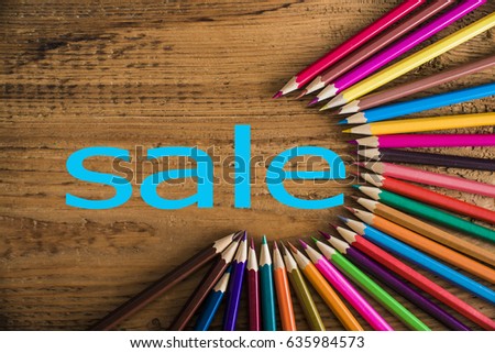  color pencils arranged in a circle on wooden background, top view. Set of multicolored pencils lying on wooden table round order. wooden background. word  sale inside round