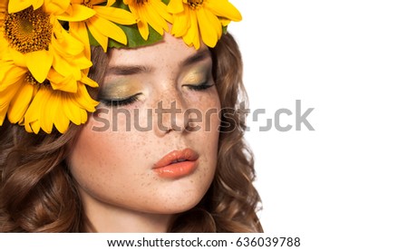 Attractive young woman with a bouquet of yellow flowers on his head. Beauty girl with curly red hair and freckles. Isolated on a white background. Color makeup, passionate lips