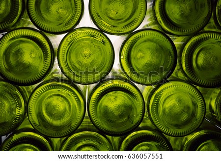  Green  bottoms of wine bottles illuminated by bright light.  Wall of back-lit green bottles. glass background, glass texture.Bottoms of green wine bottles on a white background