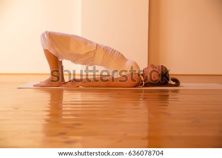 A young Woman practicing Yoga in a attic Studio.
