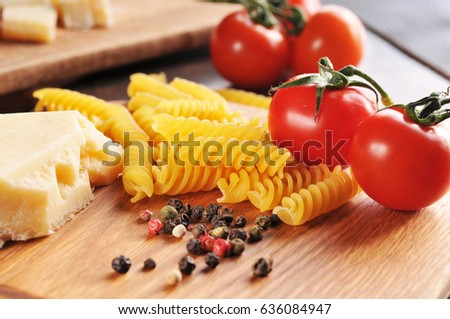 italian pasta with cheese tomatos and peppers on the wooden background