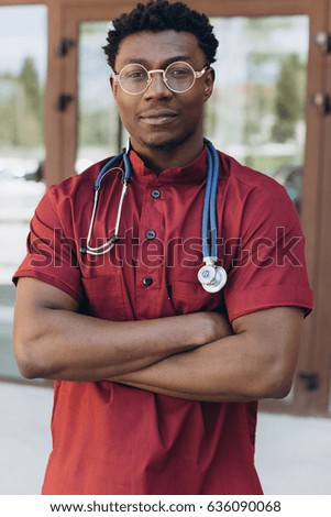 Handsome african male doctor outside of hospital building.