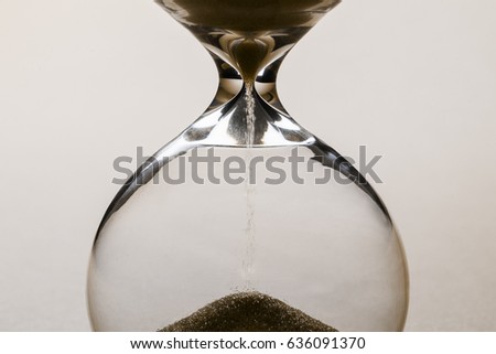 Close-up photo of brown sand clock on lighten background, time concept.