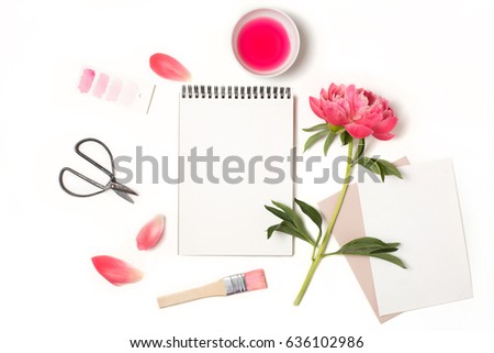 Styled feminine flat lay isolated on white background, top view. Woman's desktop with open blank notebook mock up, peony flower with petals, scissors, brush and watercolor. Artist workplace
