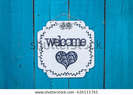 Welcome sign with metal Love heart hanging on antique rustic teal blue wood door; Mothers Day, Valentines Day, Memorial Day holiday background with painted copy space