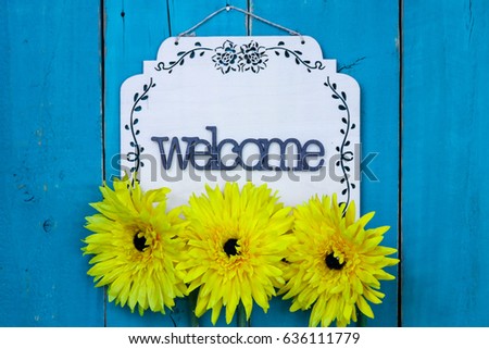 Welcome HOME sign with yellow flowers hanging on antique rustic teal blue wood door; Mothers Day, family, Memorial Day holiday background with painted copy space