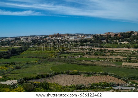 Panoramic view over the old city of Mdina surrounded by green fields - pictures take from a distance, Malta