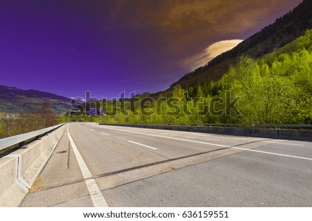 Asphalt Road on the Background of Snow-capped Alps in Switzerland at Sunset