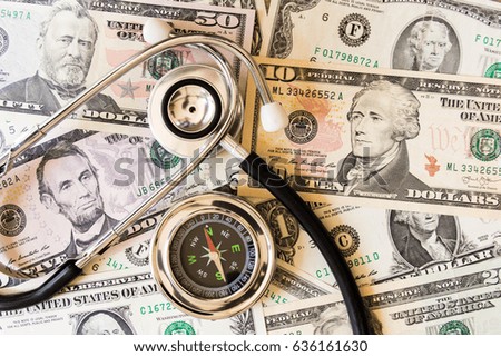 Compass and stethoscope  on dollar banknote money. 