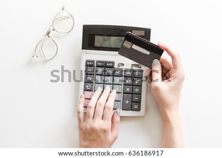 Woman holding credit card to calculate calculator the expenses.Close up people with calculator on home office.Concept business and finance