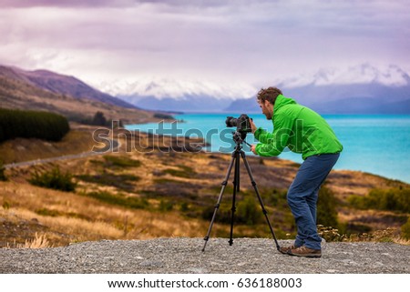 Travel photographer taking nature landscape pictures in New Zealand at sunset. Peters Lookout, Road to Mount Cook by Lake Pukaki.
