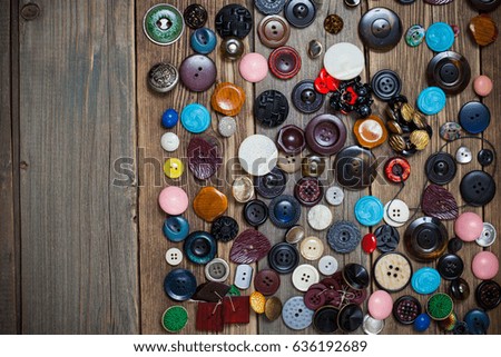 scattering of vintage stylish buttons for clothes on an old wooden surface, a still life with copy space