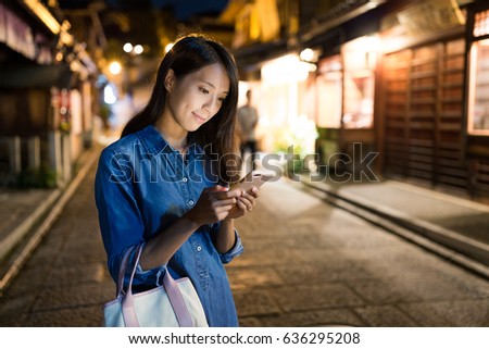 Young Woman searching on cellphone at night