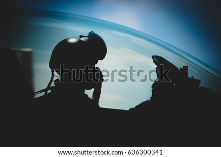 Jet pilot , The military pilot in the plane in a helmet in dark blue overalls against the blue sky Royalty-Free Stock Photo #636300341